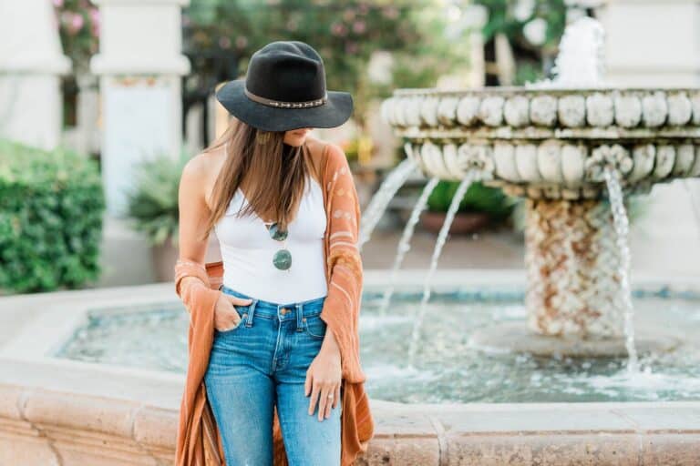 Fashionable leveled up young woman standing by a fountain