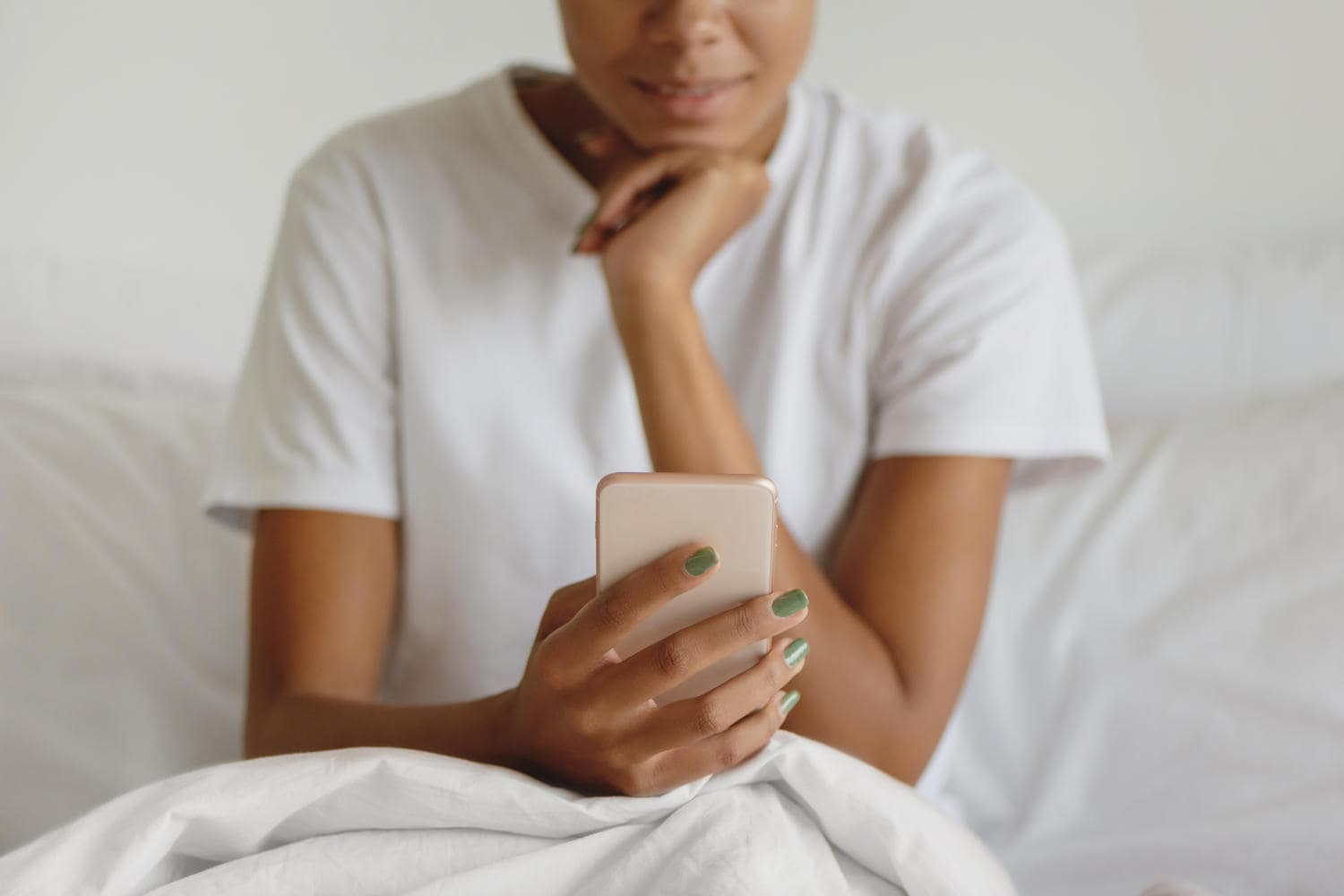 Woman sitting in bed and looking at her phone