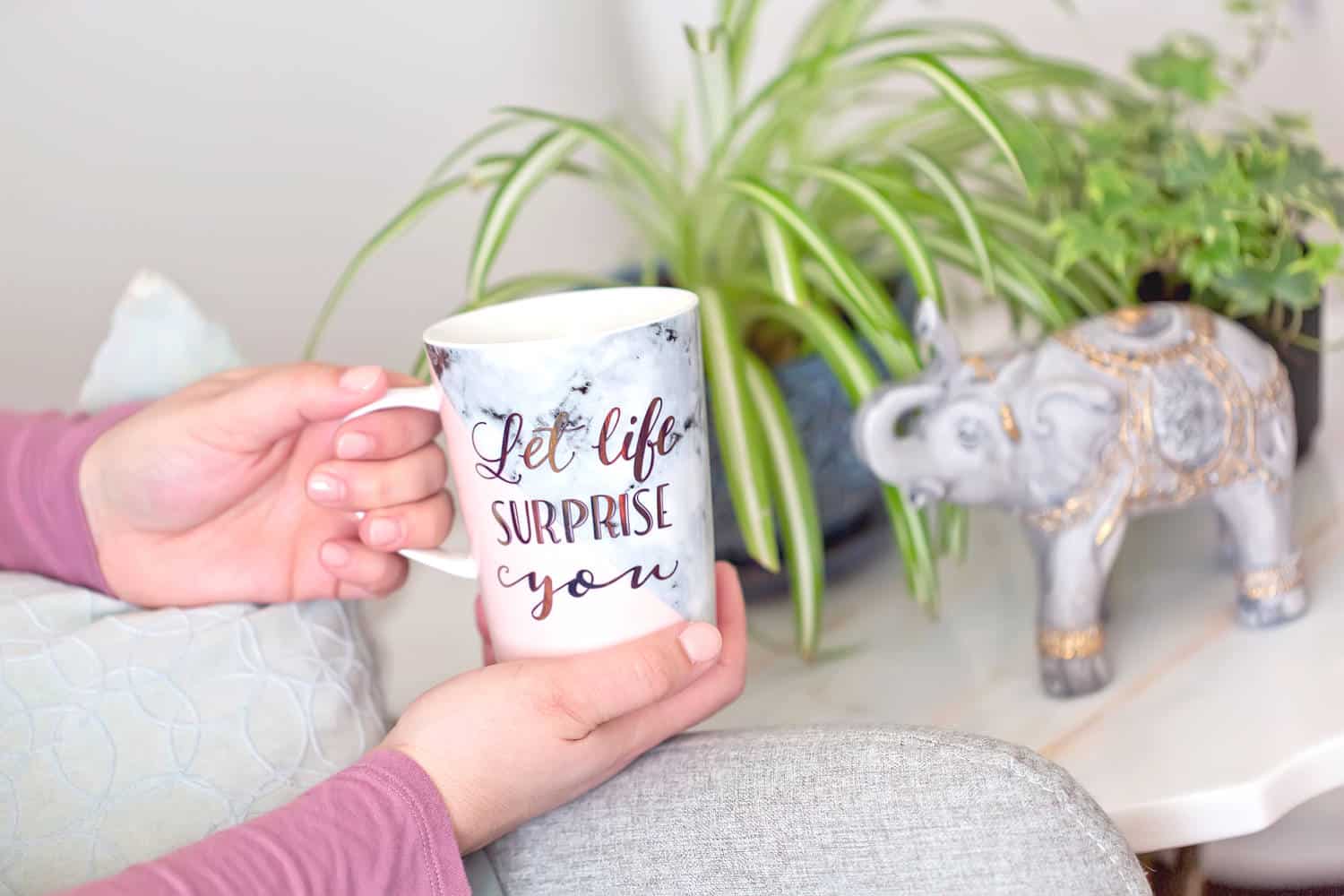 Woman holding a mug that says Let life surprise you